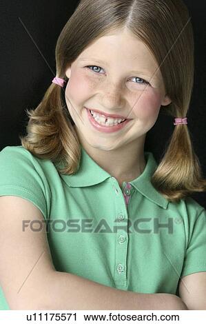 Stock Image - Young girl with pigtails in green polo shirt. Fotosearch