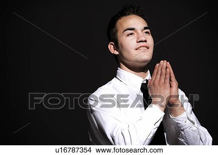 Picture - Young man praying. Fotosearch