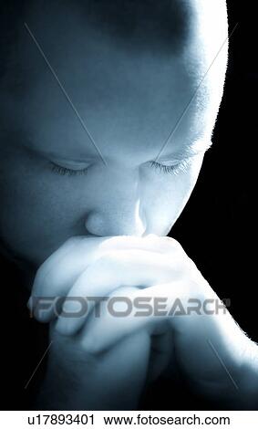 Stock Image - Young man praying. Fotosearch