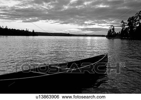 Abandoned canoe floating on water View Large Photo Image Stock Photograph - Abandoned canoe floating on water. Fotosearch