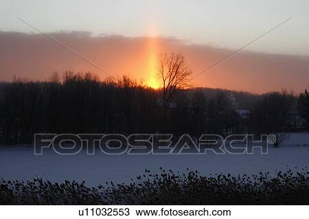 Stock Image - Beautiful sunrise behind a snow covered country town. Fotosearch
