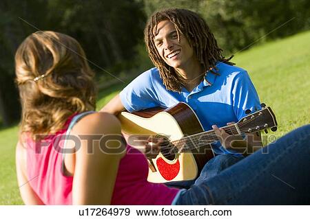 Boy playing the guitar for a girl View Large Photo Image Stock Photo - Boy playing the guitar for a girl. Fotosearch
