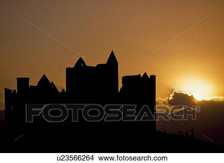 Picture - Cashel Rock, Co Tipperary, Ireland; Cashel Rock silhouetted against majestic sunset. Fotosearch