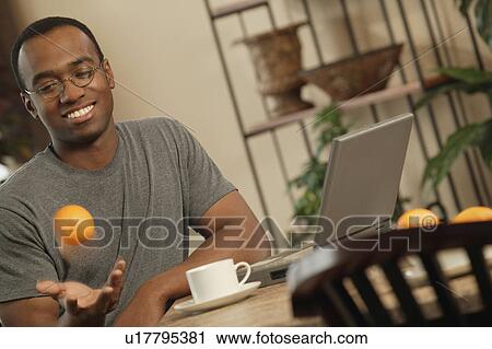 Stock Image - Catching throwing oranges. Fotosearch