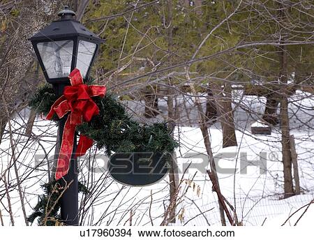 Christmas decorations wrapped around a street light View Large Photo Image Picture - Christmas decorations wrapped around a street light. Fotosearch