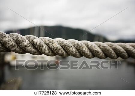 Close up thick rope, with fishing boats in background View Large Photo Image Stock Photo - Close up thick rope, with fishing boats in background. Fotosearch