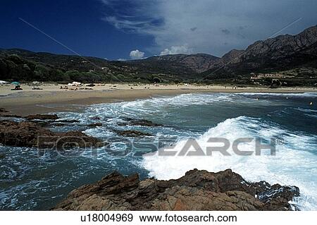 Stock Photo - Corsica, France; People enjoying the sun on a Mediterranean beach. Fotosearch