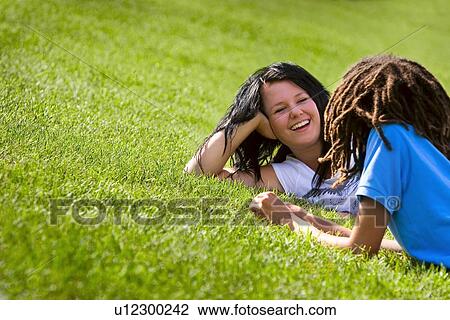 Couple laying on the grass View Large Photo Image Stock Image - Couple laying on the grass. Fotosearch