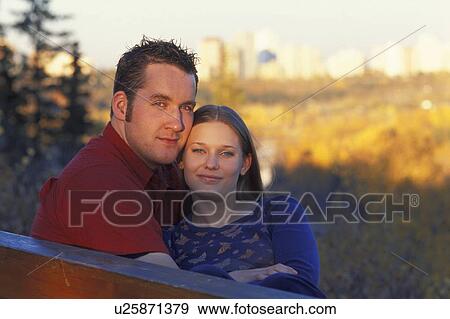 Couple on a park bench View Large Photo Image Stock Photo - Couple on a park bench. Fotosearch