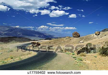 Stock Image - Death Valley, California, USA; Winding road in front of expansive desert. Fotosearch