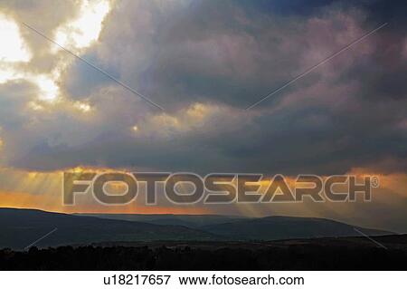 Stock Photo - Derbyshire, England, United Kingdom; Sunbeams striking through clouds. Fotosearch