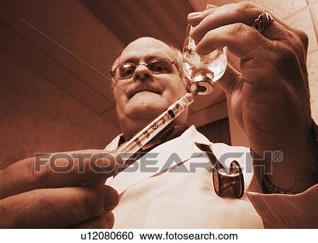 Doctor drawing injection View Large Photo Image Stock Image - Doctor drawing injection. Fotosearch