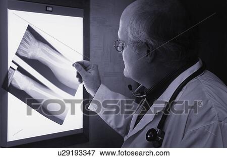 Doctor examining x-ray View Large Photo Image Stock Photo - Doctor examining x-ray. Fotosearch