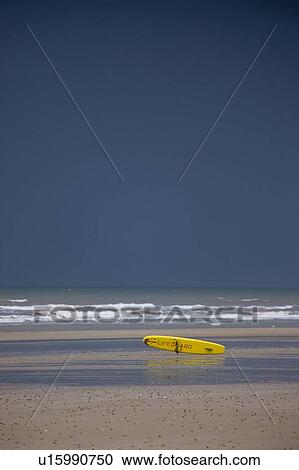 Stock Image - East Riding, Yorkshire, England; Surf rescue board lying on the foreshore. Fotosearch