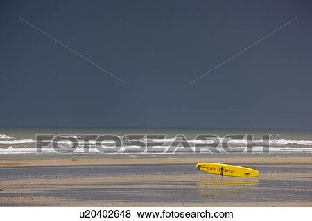 Stock Photo - East Riding, Yorkshire, England; Surf rescue board lying on the foreshore. Fotosearch