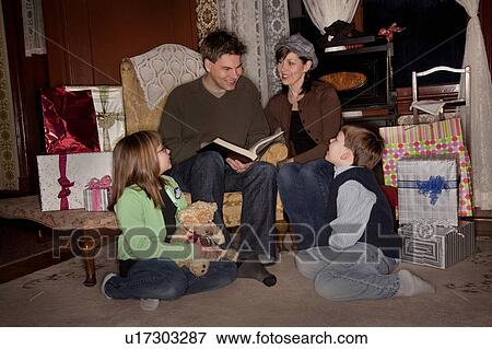 Stock Photo - Family reading a story at Christmas time. Fotosearch