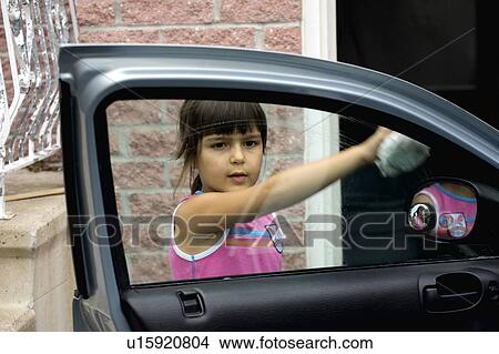 Picture - Girl cleaning car window. Fotosearch