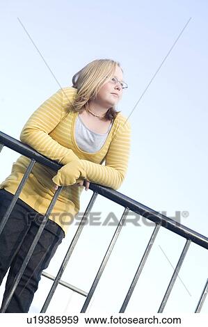 Stock Photo - Girl leaning on railing. Fotosearch