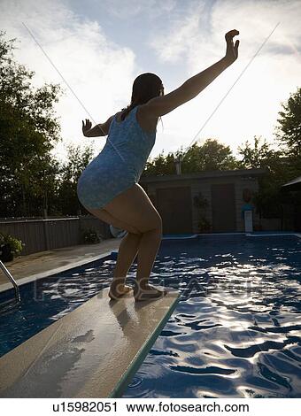 Girl on diving board over swimming pool View Large Photo Image Stock Image - Girl on diving board over swimming pool. Fotosearch