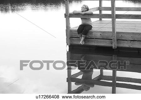 Stock Photo - Girl sitting on a dock. Fotosearch