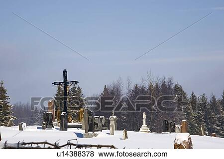 Gravestones in a cemetery covered in snow View Large Photo Image Stock Photo - Gravestones in a cemetery covered in snow. Fotosearch