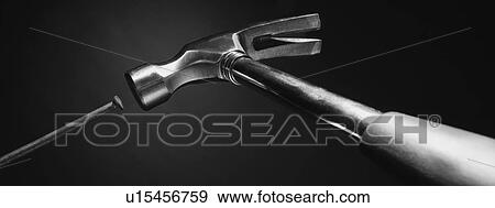 Stock Photo - Hammer hitting the nail (black and white). Fotosearch