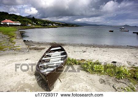 Stock Photo - Islay, Scotland; An abandoned canoe by a beach. Fotosearch
