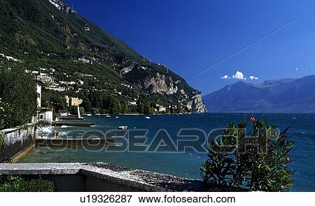 Italy; Lake Garda surrounded by buildings and a marina View Large Photo Image Stock Photo - Italy; Lake Garda surrounded by buildings and a marina. Fotosearch