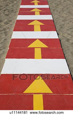 Stock Image - La Carihuela Torremolinos, Costa del Sol, Spain; Arrows on pathway. Fotosearch