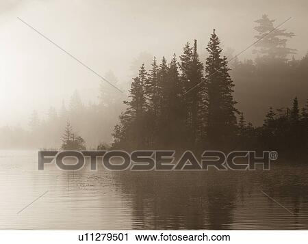 Stock Image - Lake of the Woods, Ontario, Canada; Mist rises over lake. Fotosearch