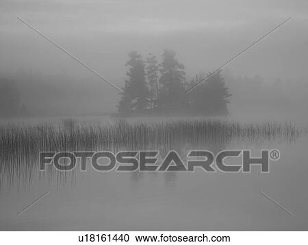 Stock Image - Lake of the Woods, Ontario, Canada; Mist rises over lake. Fotosearch