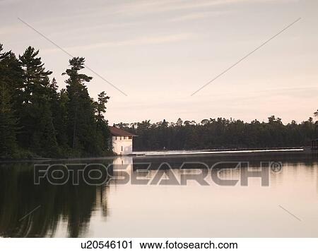 Stock Image - Lake of the Woods, Ontario, Canada; Early morning view to boat house. Fotosearch