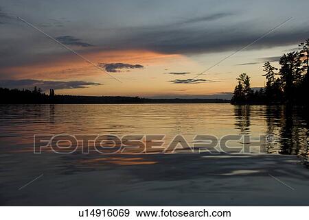 Lake of the Woods, Ontario, Canada; Reflection of majestic sunset in placid lake View Large Photo Image Stock Photo - Lake of the Woods, Ontario, Canada; Reflection of majestic sunset in placid lake. Fotosearch
