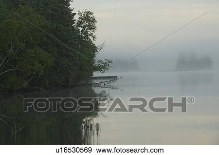 Stock Photo - Lake of the Woods, Ontario, Canada; View across lake at sunrise. Fotosearch