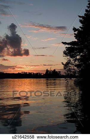 Lake of the Woods, Ontario, Canada; Majestic sunset over placid lake View Large Photo Image Stock Photo - Lake of the Woods, Ontario, Canada; Majestic sunset over placid lake. Fotosearch