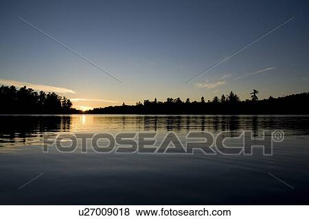 Stock Photo - Lake of the Woods, Ontario, Canada; Sunset over lake. Fotosearch