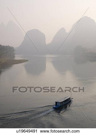 Stock Image - Li River, Yangshuo county, Guilin, Guangxi Province, China; Boat on the river. Fotosearch