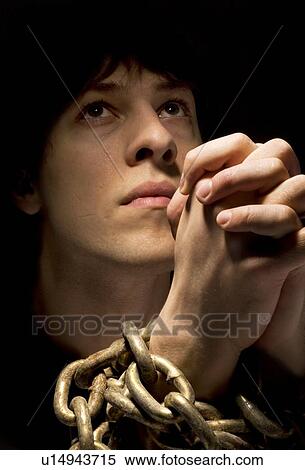 Stock Photography - Man in chains, praying. Fotosearch