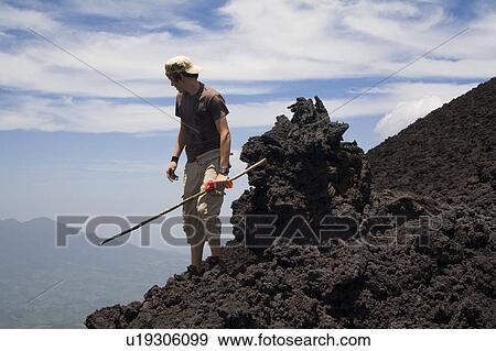 Man on a hill; Man with a stick looking down a hill View Large Photo Image Stock Photo - Man on a hill; Man with a stick looking down a hill. Fotosearch