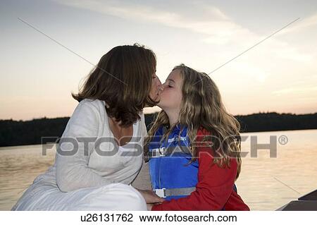 Stock Image - Mother and daughter kiss, Lake of the Woods, Ontario, Canada. Fotosearch