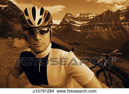 Picture - Mountain biker with mountain range backdrop. Fotosearch