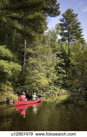 Muskokas, Ontario, Canada; couple canoeing down a river View Large Photo Image Stock Photo - Muskokas, Ontario, Canada; couple canoeing down a river. Fotosearch