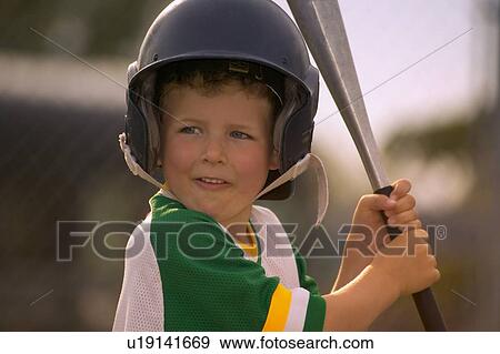 Stock Photo - Portrait of Boy Wearing Baseball Uniform and Helmet Holding Bat. Fotosearch