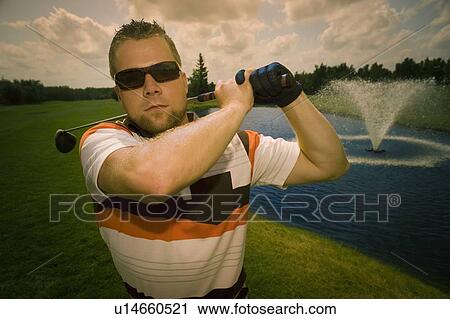 Stock Image - Portrait of young male golfer. Fotosearch