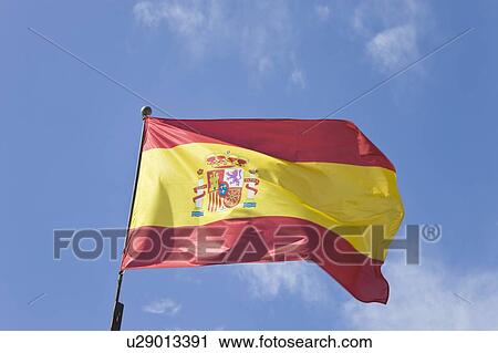 Spanish flag rippling in the breeze against a blue sky View Large Photo Image Stock Image - Spanish flag rippling in the breeze against a blue sky. Fotosearch