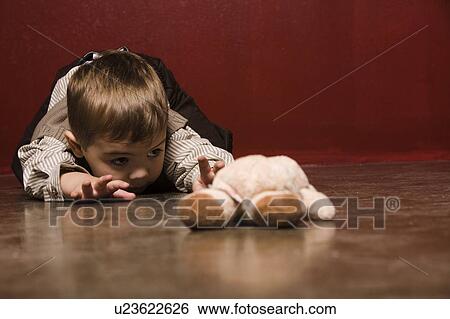 Toddler crawling on floor reaching for teddy bear View Large Photo Image Stock Photograph - Toddler crawling on floor reaching for teddy bear. Fotosearch