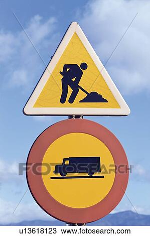 Stock Image - Traffic signs; Men at work and no entry for trucks traffic signs. Fotosearch