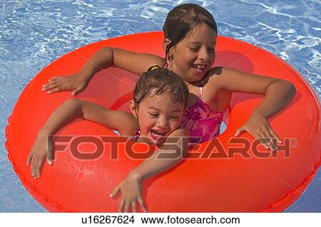 Two girls with rubber ring in pool View Large Photo Image Picture - Two girls with rubber ring in pool. Fotosearch