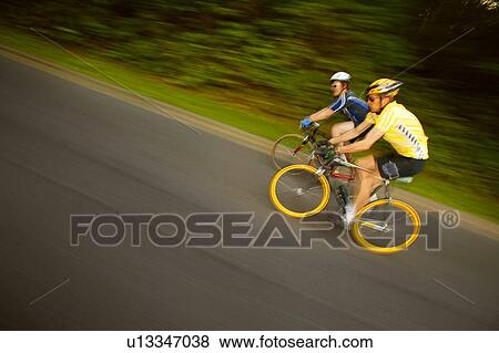 Two people racing on bikes View Large Photo Image Stock Photo - Two people racing on bikes. Fotosearch