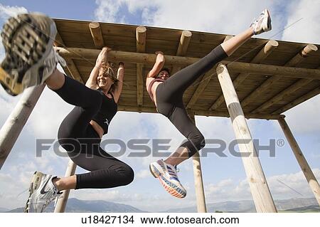 Two women hanging from wooden structure View Large Photo Image Picture - Two women hanging from wooden structure . Fotosearch